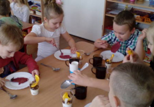 Dzieci przy stole podczas degustacji deserów.